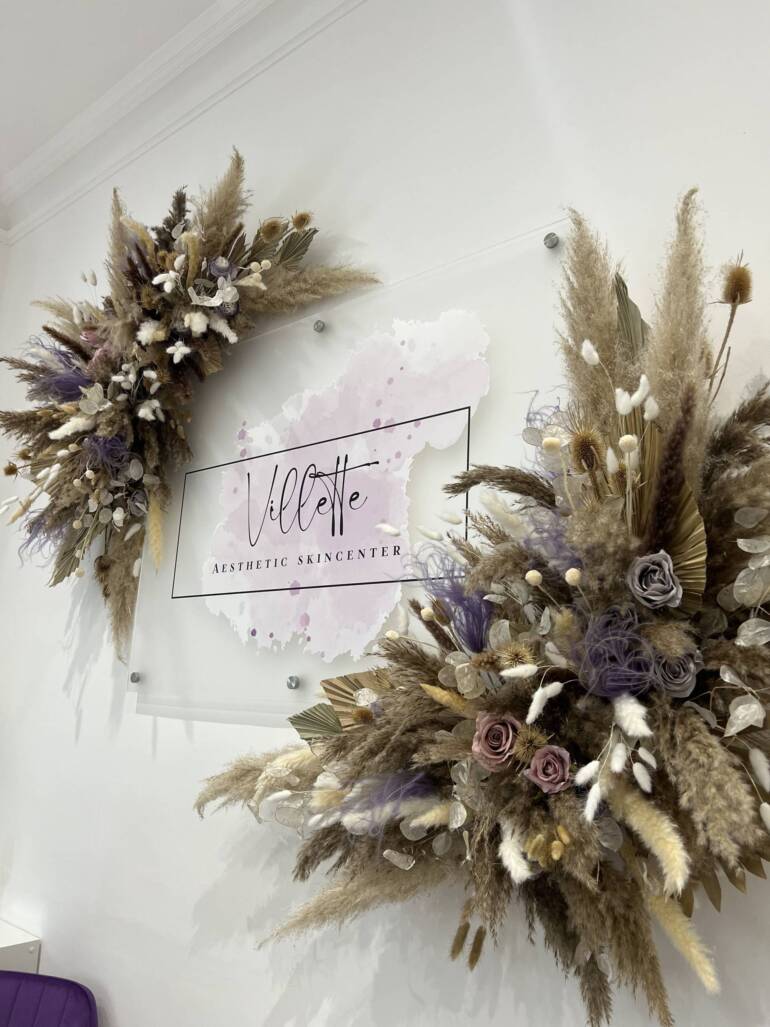 Floral installation that is both airy and opulent, highlighting a wide variety of dried flowers and plants in soothing shades of nude and lavender. Perfectly designed to enhance the brand identity of a skincare clinic logo.