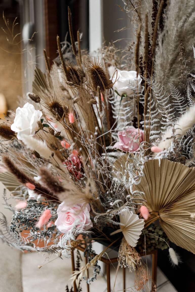 A selection of dried plants and preserved roses, artfully arranged for a grand opening display event, elegance, and charm for a sophisticated ambiance.