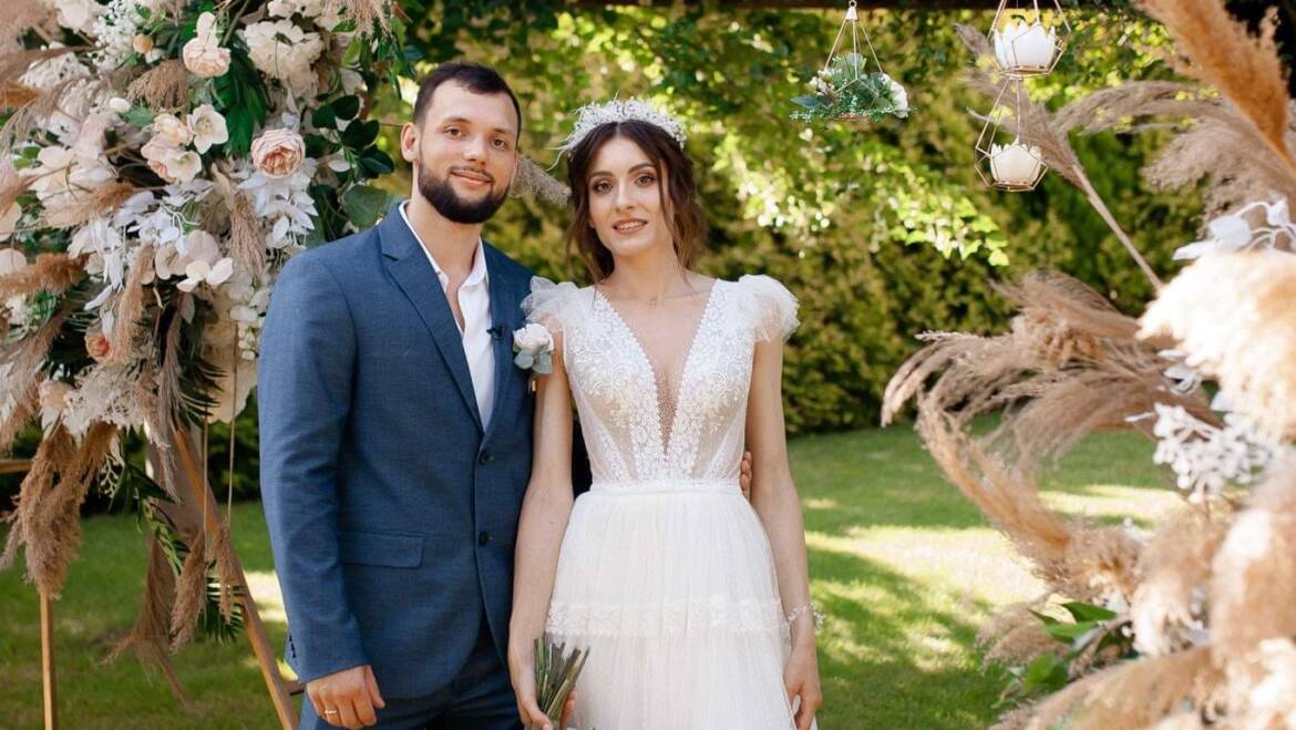Summer wedding with dried plants and faux flowers in soft dusty pink, creating a romantic and enchanting atmosphere.