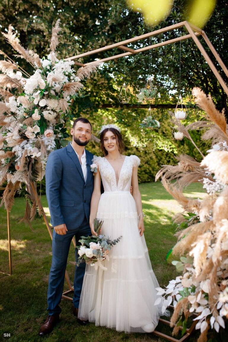 Summer wedding with dried plants and faux flowers in soft dusty pink, creating a romantic and enchanting atmosphere.
