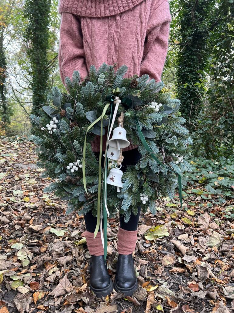 Festive decoration made of artificial greenery and berries in scandinavian style.