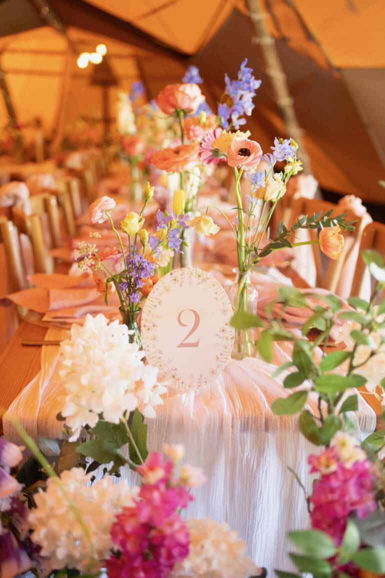 A pastel dream unfolding through the tipi, where flowers whisper like soft confetti and greenery drapes like a gentle, floating veil, turning the space into a cloud of romance and light