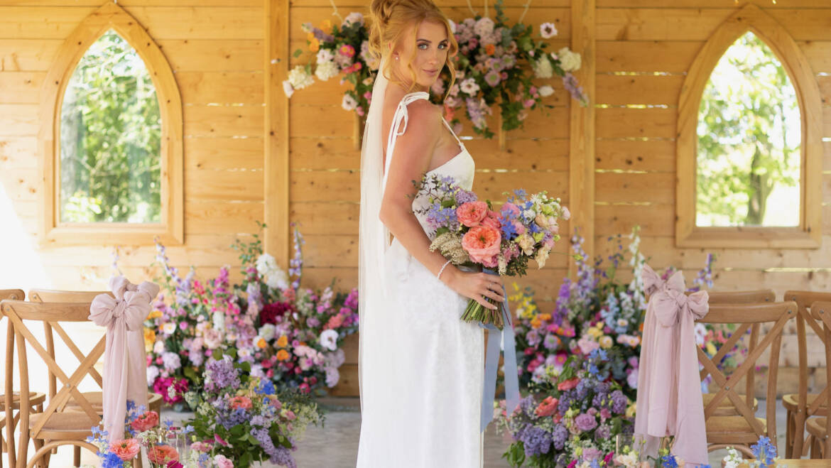 Ceremony space  filled with soft pastel blooms and gentle greenery, creating a serene, romantic, and airy floral setting
