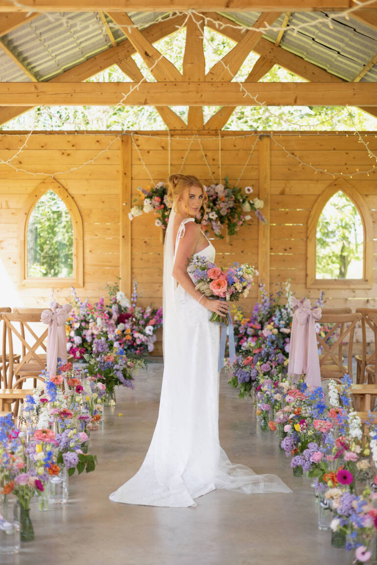 Ceremony space  filled with soft pastel blooms and gentle greenery, creating a serene, romantic, and airy floral setting