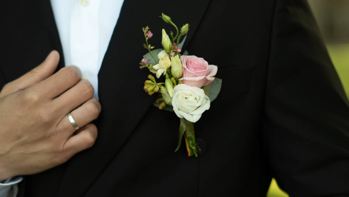 A groom’s buttonhole in soft pink and ivory, fresh and delicate