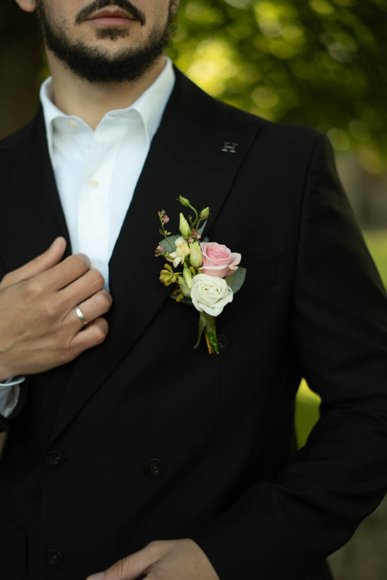 A groom’s buttonhole in soft pink and ivory, fresh and delicate
