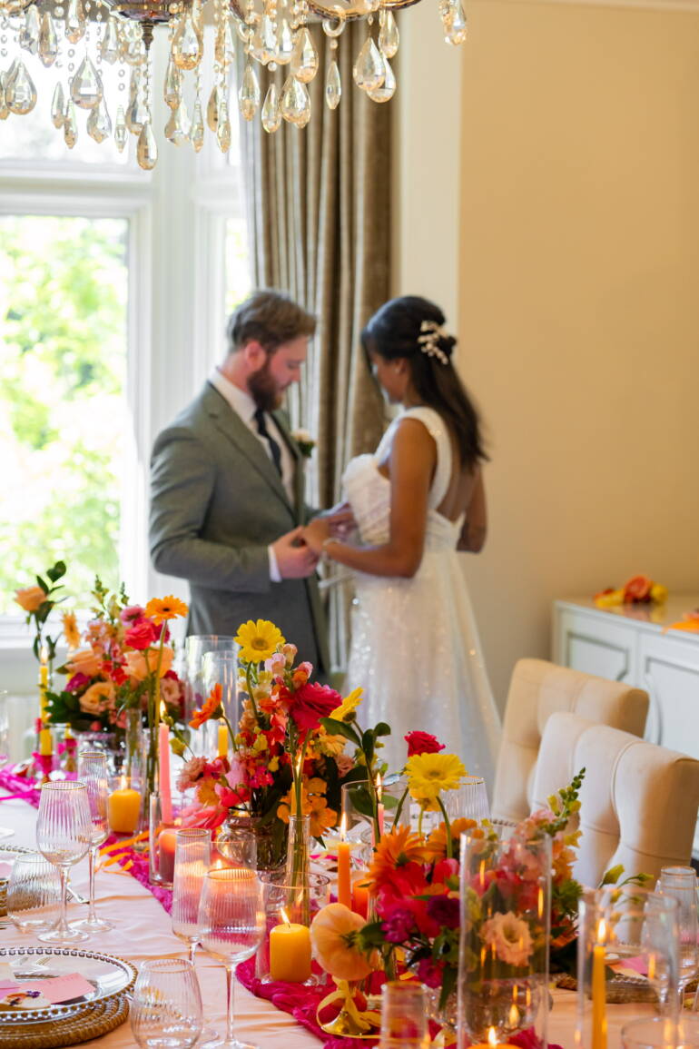 Bold, colourful  table flower arrangements, paired with fresh, juicy citrus fruits- a vibrant, lively, and refreshingly playful table setting.