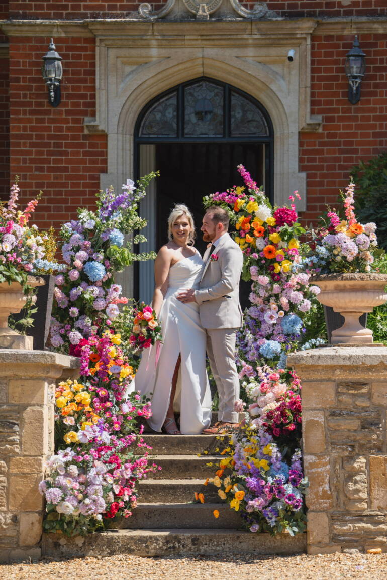 Cascading flowers in a bold, colorful mix flow through the wedding, intertwined with fresh, juicy citrus fruits – a vibrant, lively, and refreshing celebration