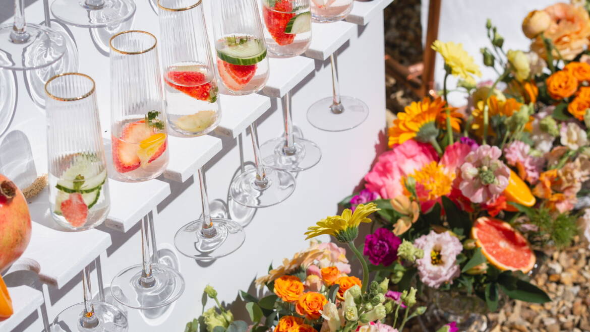Cascading flowers in a bold, colorful mix flow through the wedding, intertwined with fresh, juicy citrus fruits – a vibrant, lively, and refreshing celebration
