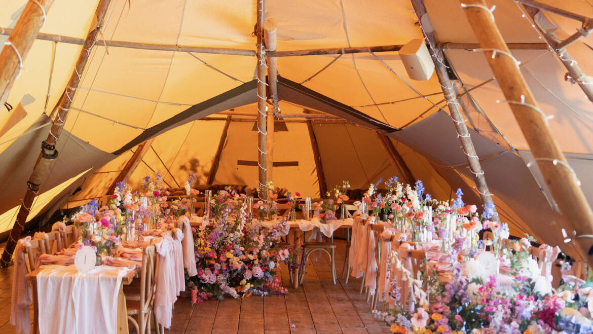 A pastel dream unfolding through the tipi, where flowers whisper like soft confetti and greenery drapes like a gentle, floating veil, turning the space into a cloud of romance and light